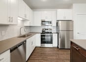 Thumbnail 8 of 30 - A modern kitchen with stainless steel appliances and white cabinets.
