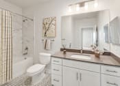 Thumbnail 13 of 30 - A white bathroom with a marble shower and a brown counter.