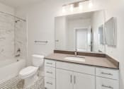 Thumbnail 14 of 30 - A white bathroom with a marble patterned shower.