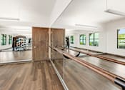 Thumbnail 25 of 35 - A room with a wooden floor and a mirrored wall.