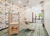 Thumbnail 14 of 35 - A room with a colorful wallpaper and a wooden play structure.