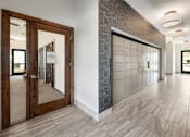 Thumbnail 8 of 35 - A hallway with a tiled floor and a wall with a stone pattern.