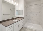 Thumbnail 11 of 35 - A white bathroom with a marble shower.