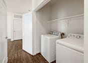 Thumbnail 24 of 35 - A small laundry room with a washer and dryer.