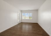 Thumbnail 26 of 35 - A room with wooden flooring and a window with blinds.