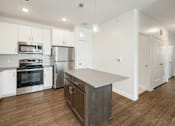 Thumbnail 20 of 35 - A modern kitchen with stainless steel appliances and wooden floors.
