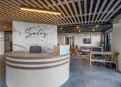 Thumbnail 2 of 28 - A reception area with a white reception desk and a sign that says "Sales".