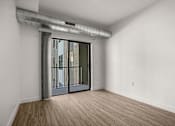 Thumbnail 18 of 28 - A room with a sliding glass door leading to a balcony.