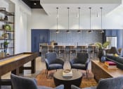 Thumbnail 6 of 26 - a lobby area with chairs and tables and a bar