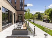 Thumbnail 25 of 26 - the sidewalk outside of a building with tables and benches