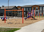 Thumbnail 18 of 35 - A playground with a purple slide and orange poles.