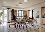 Thumbnail 8 of 10 - a dining area with a wooden table and chairs and a kitchen in the background