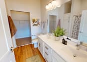 Thumbnail 46 of 49 - A bathroom with a white counter and a brown towel hanging on the door.