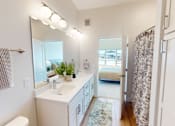 Thumbnail 47 of 49 - A bathroom with a white sink and a mirror.