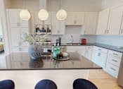 Thumbnail 41 of 49 - A modern kitchen with a glass table and blue chairs.