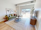 Thumbnail 42 of 49 - A living room with a green couch, a coffee table, and a television.