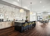 Thumbnail 3 of 49 - A modern kitchen with a marble backsplash and dark wood floors.