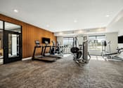 Thumbnail 7 of 49 - A spacious gym with treadmills, weights, and exercise bikes.