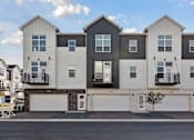 Thumbnail 18 of 49 - A row of modern townhouses with balconies and garages.