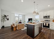 Thumbnail 19 of 49 - A modern kitchen with a wooden floor and white walls.