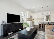 Thumbnail 22 of 49 - A black TV sits on a black cabinet in a modern living room.