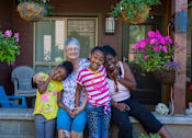 Thumbnail 1 of 5 - a woman sitting on a porch with three girls