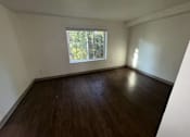 Thumbnail 13 of 18 - A room with wooden flooring and a window.
