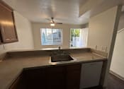 Thumbnail 18 of 18 - A kitchen with a brown countertop and a white dishwasher.