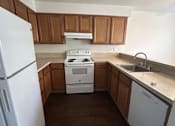 Thumbnail 14 of 18 - A white refrigerator stands in a kitchen with wooden cabinets.