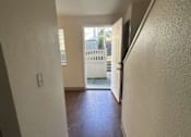 Thumbnail 16 of 18 - A hallway with a wooden floor and white walls.