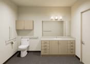 Thumbnail 16 of 28 - A bathroom with a toilet, sink, and cabinets.