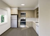 Thumbnail 15 of 28 - A kitchen with a refrigerator, oven, and microwave.