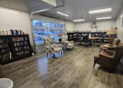 Thumbnail 20 of 27 - A library with a lot of books and chairs.