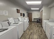 Thumbnail 22 of 27 - A laundromat with washers and dryers lined up.