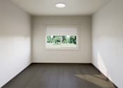 Thumbnail 13 of 28 - A room with a window that shows a green outdoor scene.