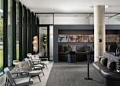 Thumbnail 5 of 24 - A modern living room with a black couch and grey chairs at Miles at Ybor Apartments, Tampa, FL