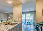 Thumbnail 28 of 37 - A kitchen with a marble countertop and blue chairs.