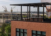 Thumbnail 18 of 19 - A red brick building with a balcony overlooking a construction site.