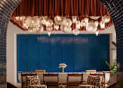 Thumbnail 2 of 19 - A room with a blue door and a brown chair.