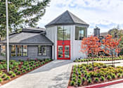 Thumbnail 11 of 11 - Exterior of Hangar 128 Apartment Homes with turret style architecture and a red door at Hangar 128 Apartments Homes in Everett, WA