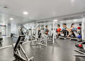 Thumbnail 25 of 33 - A gym with people working out and various exercise equipment.