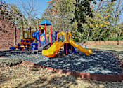 Thumbnail 19 of 33 - A playground with a blue and yellow slide and a red and yellow structure.