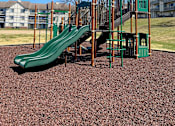 Thumbnail 29 of 33 - Playground with green slides and climbing structure at River Oaks at Rochester Hills Apartments.