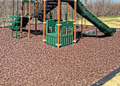 Thumbnail 28 of 33 - Green and brown playground tower with slide at River Oaks at Rochester Hills Apartments.