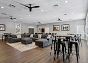 Thumbnail 17 of 33 - A modern living room with a dark wood floor and a white ceiling with multiple ceiling fans.