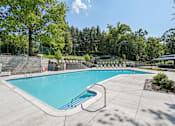 Thumbnail 22 of 33 - Resort-style outdoor pool and lounge area at River Oaks at Rochester Hills Apartments.