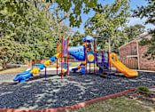 Thumbnail 39 of 43 - A playground with a blue and yellow slide, a red and yellow slide, and a yellow slide Georgetown of St. Louis Apartments