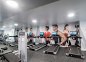 Thumbnail 23 of 33 - A gym with people exercising on treadmills.