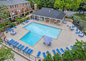 Thumbnail 12 of 33 - Georgetown Apartments of St. Louis pool deck with blue lounge chairs, tables, and umbrellas.