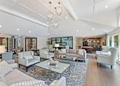 Thumbnail 20 of 33 - Spacious furnished community lounge with seating, pool table, and large windows at River Oaks at Rochester Hills.